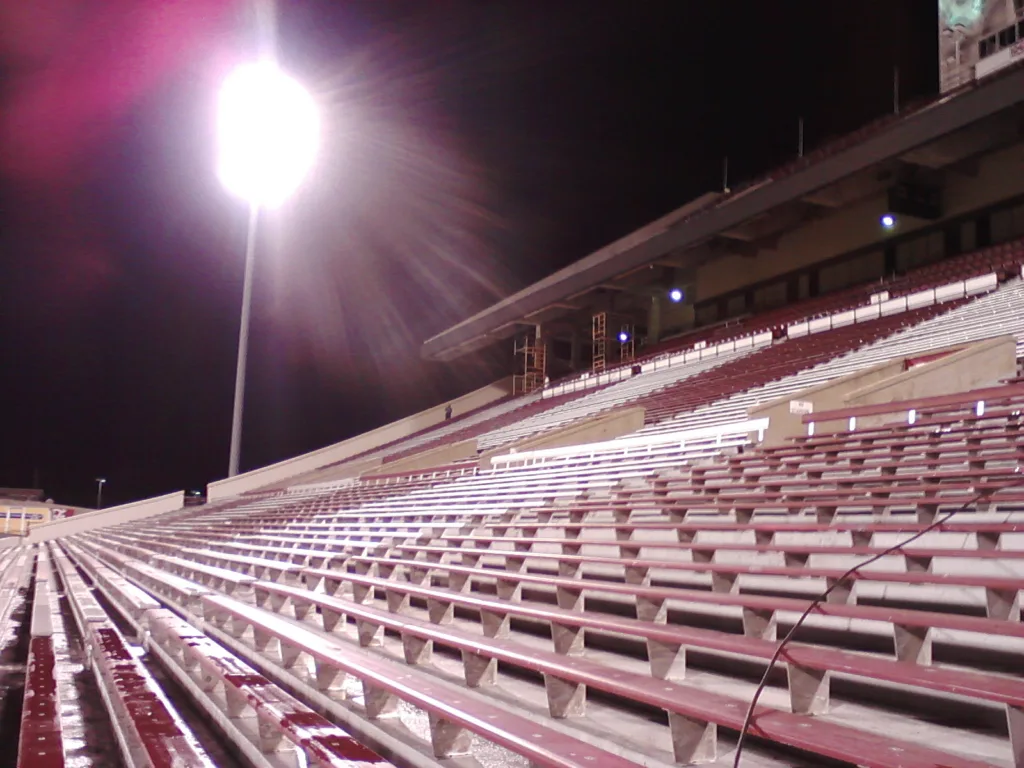 Commercial pressure washing service cleaning stadium bleachers and concrete seating in Norman Oklahoma - Nighttime perspective