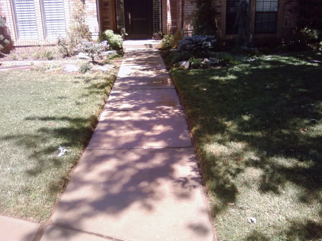 Residential pressure washing service cleaning concrete sidewalk in Norman Oklahoma After