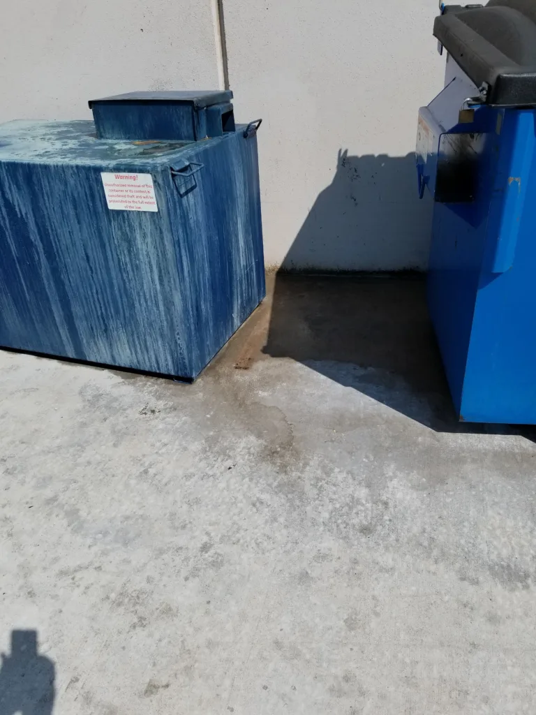 Commercial pressure washing service cleaning dirty oil and grease from dumpster pad concrete - After clean result