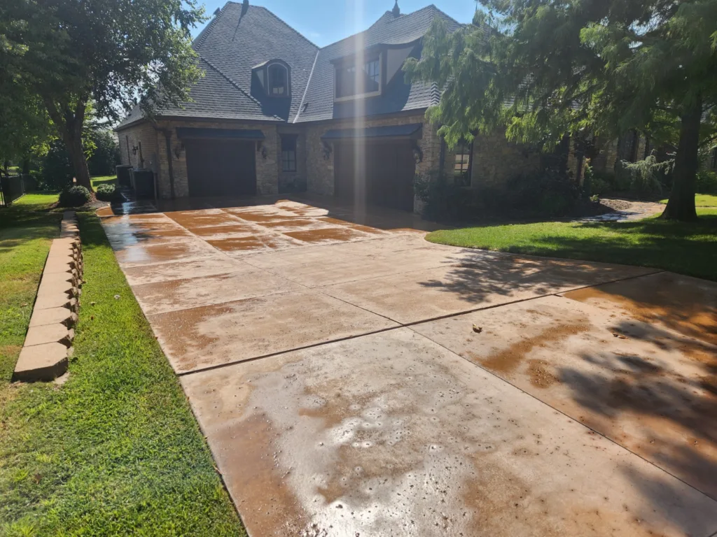 Residential pressure washing service cleaning stamped concrete driveway in Edmond Oklahoma