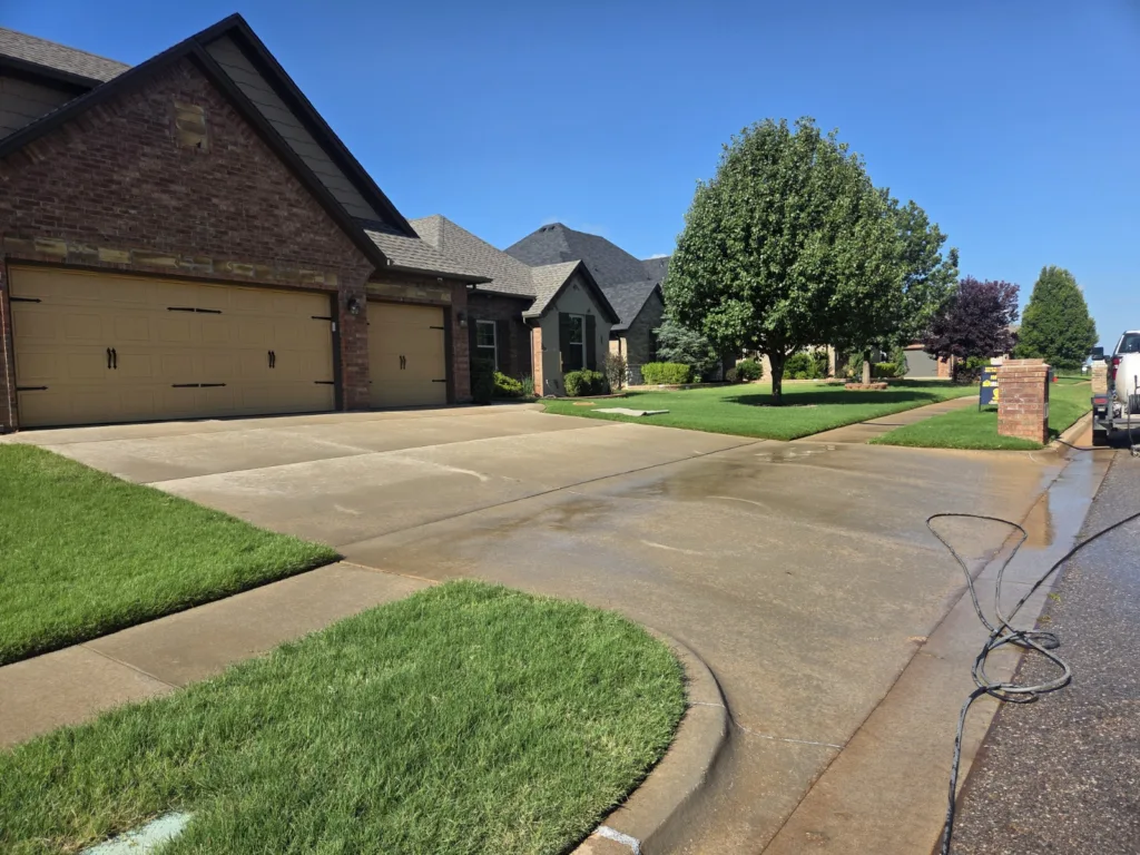 Residential pressure washing service cleaning concrete driveway in Yukon Oklahoma