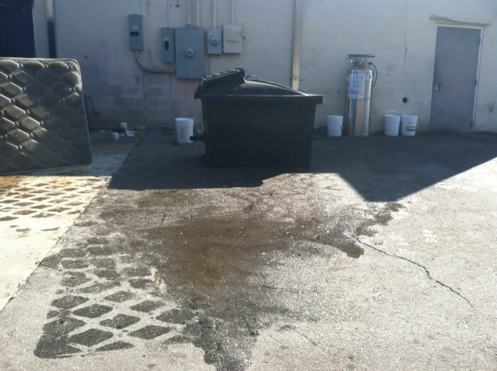 Commercial pressure washing service cleaning dumpster pad concrete in Mustang Oklahoma - Before transformation