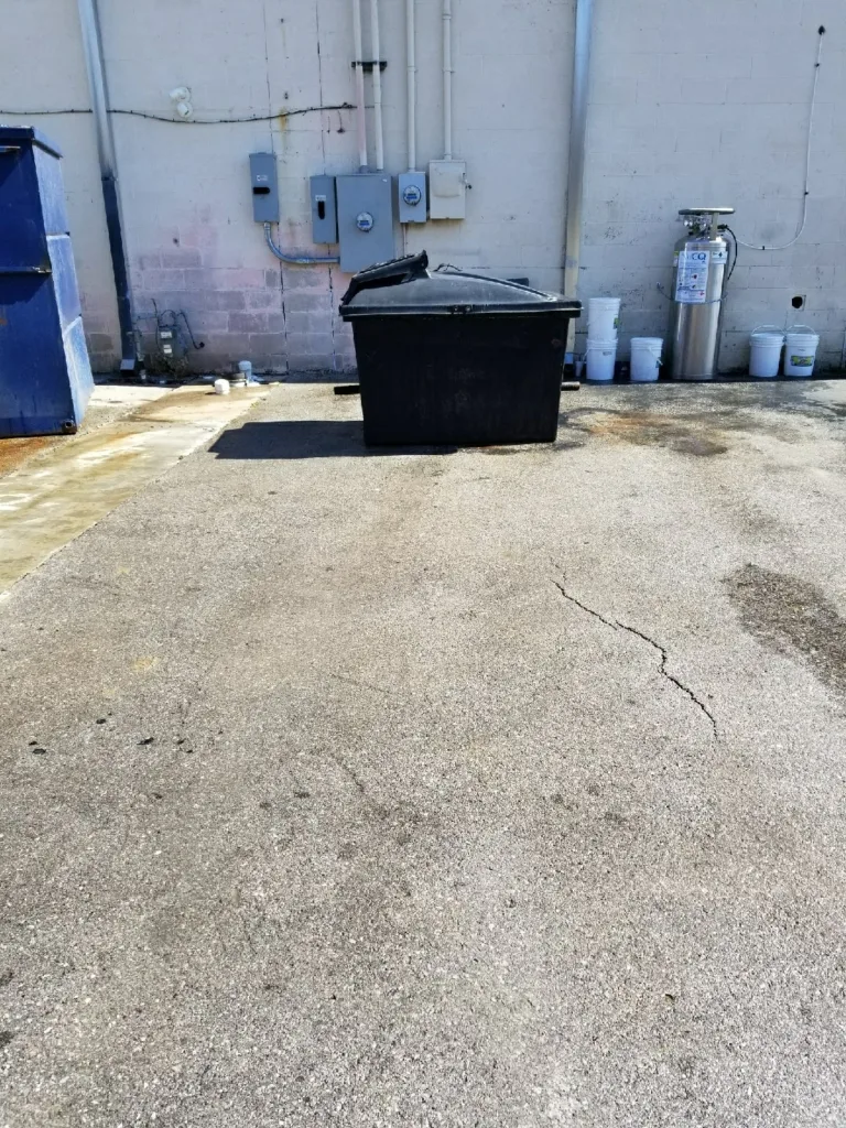 Commercial pressure washing service cleaning dumpster pad concrete in Mustang Oklahoma - After clean result