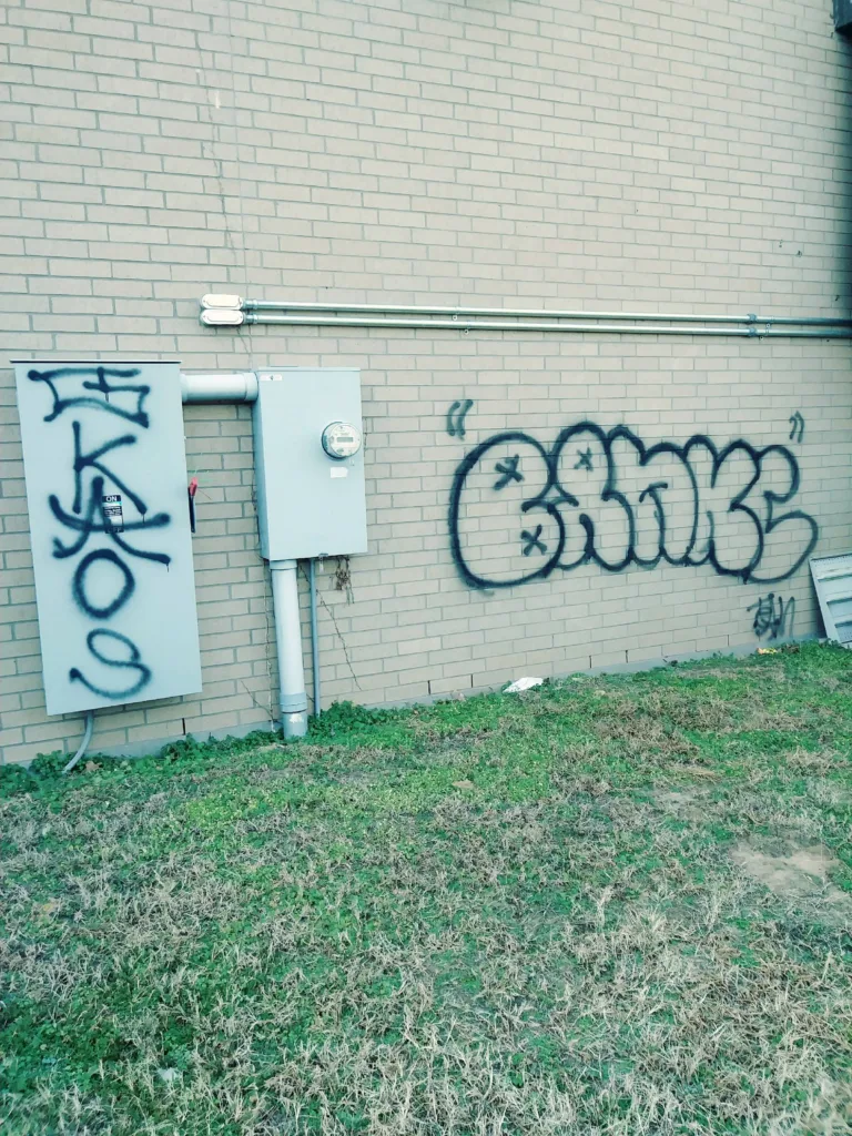 Commercial graffiti removal service cleaning spray paint off brick wall in Oklahoma City OK - Before transformation
