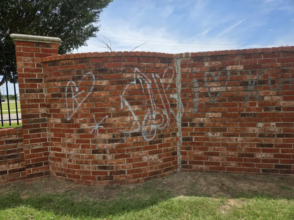 Graffiti removal service cleaning spray paint off brick wall - Before transformation